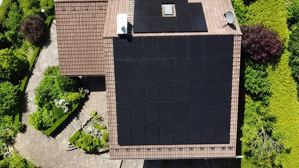 Dachfläche von oben mit großem Feld schwarzer Photovoltaik-Module